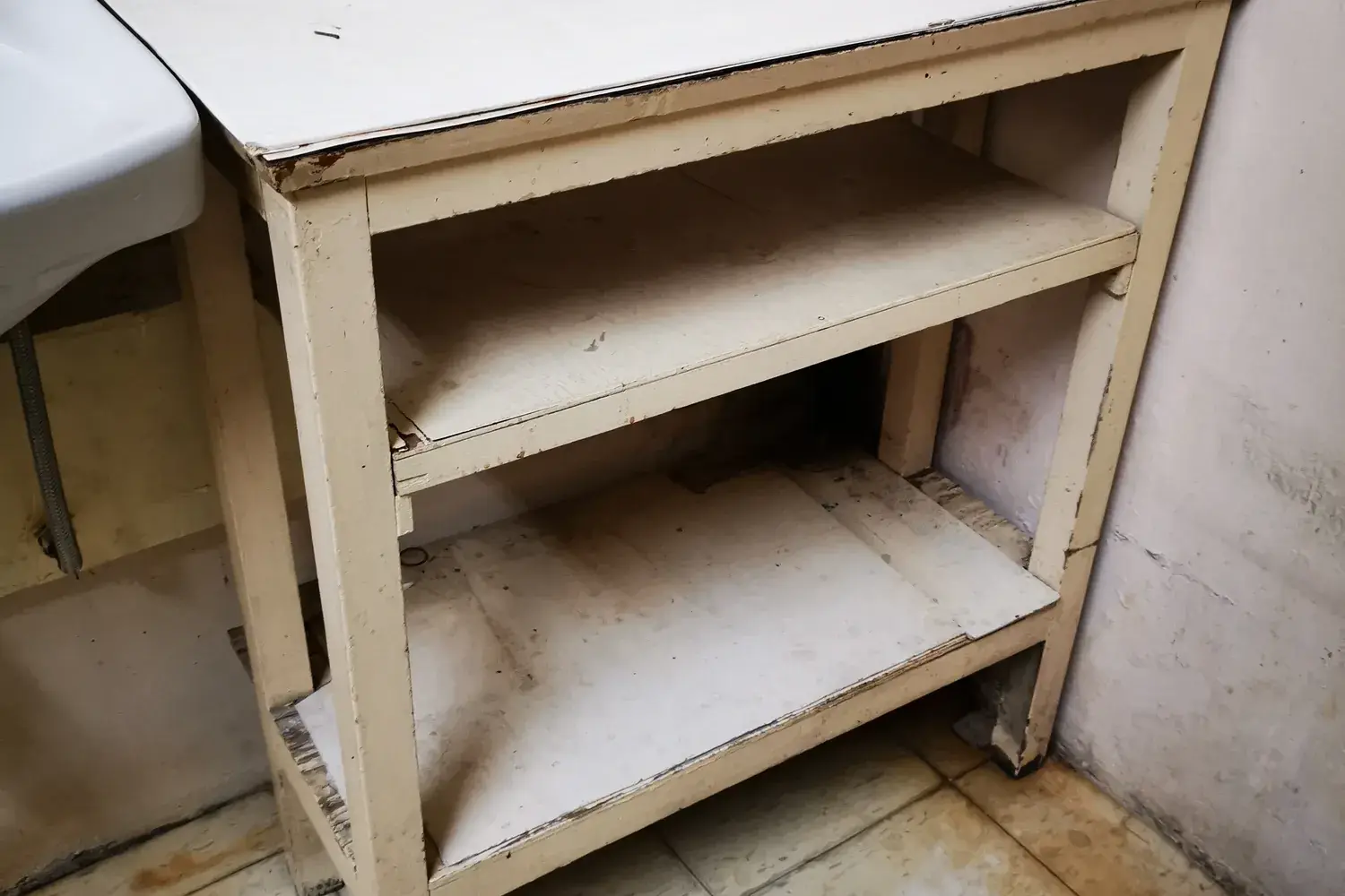 A simple painted wooden shelf unit with fixed shelves