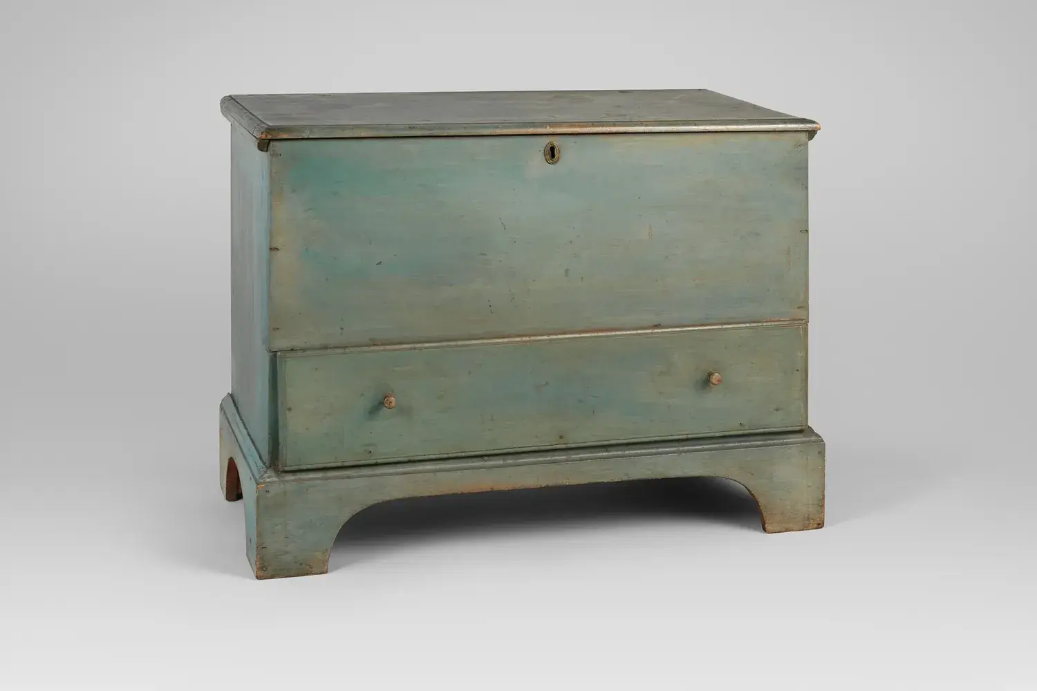 An antique painted Shaker blanket chest with a lift lid and a drawer below