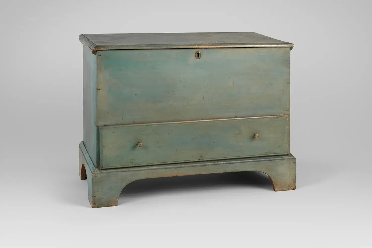 An antique painted Shaker blanket chest with a lift lid and a drawer below