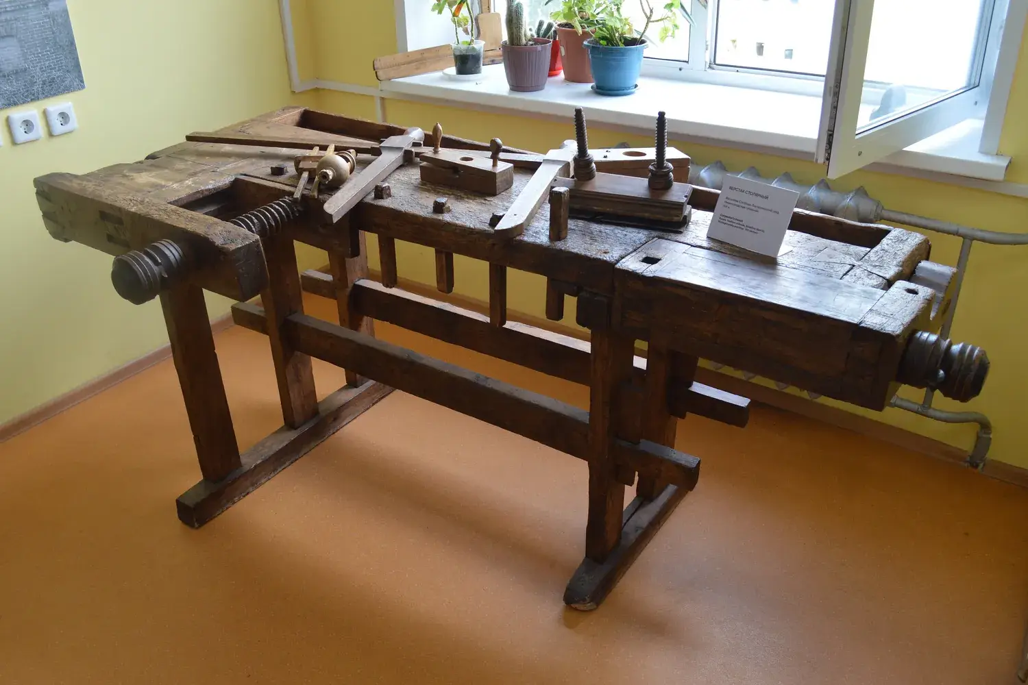 A heavy 19th-century wooden joiner's workbench with vises in a museum